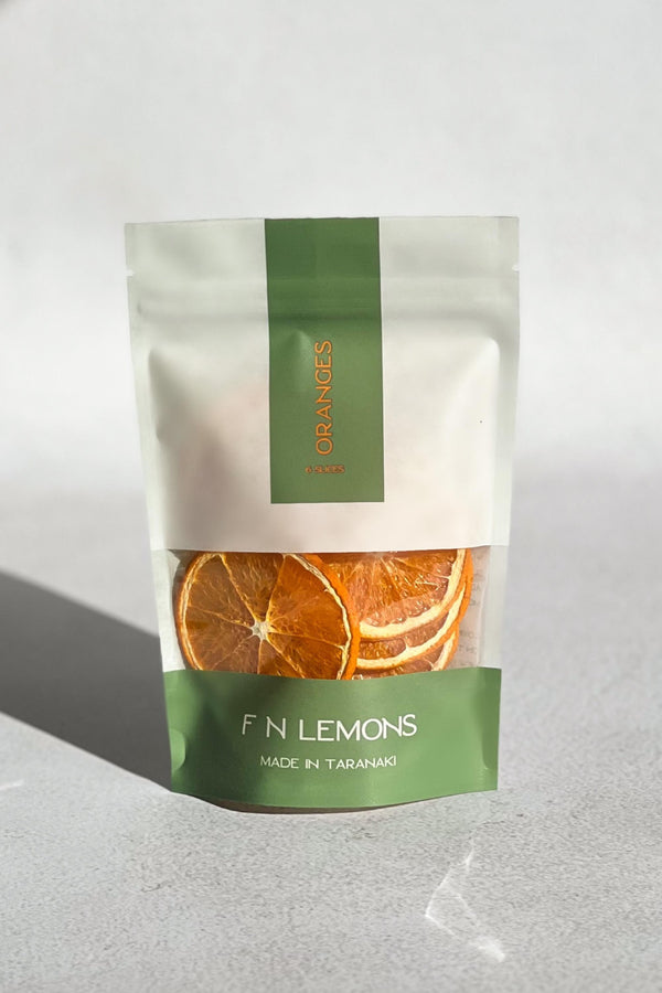 The F N Lemons - Oranges 6 Slice Pouch features dried orange slices in a resealable pack labeled "ORANGES." The bottom reads "FN LEMONS MADE IN TARANAKI" in white on green. Ideal as a premium garnish for cocktails or baking.