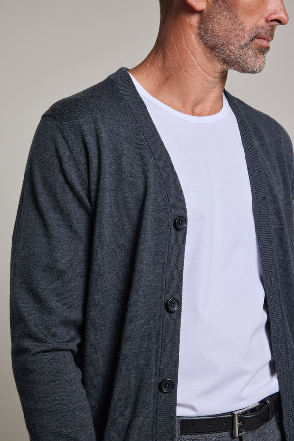 A man with a short beard models the Barkers Skyland ZQrx Merino Cardi—an ethically sourced cardigan—over a white T-shirt. Shown from shoulders to waist, he faces slightly right against a neutral background.