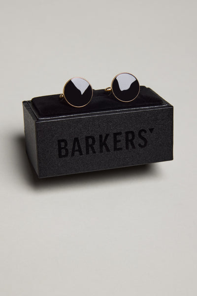 The Barkers Gold and Black Round Cufflink is shown on a black velvet holder atop a Barkers box, all set against a plain light gray background.