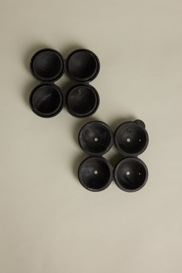 Four Barkers Ice Tray Sphere Marble Black molds are at the top left, with another four arranged diagonally below. Each set resembles large round cocktail ice spheres, all displayed on a plain beige background.