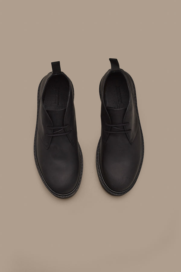 The Howarth Desert Boot by Barkers—black leather boots with laces and pull tabs in classic Portuguese style—are displayed side by side on a plain beige background.