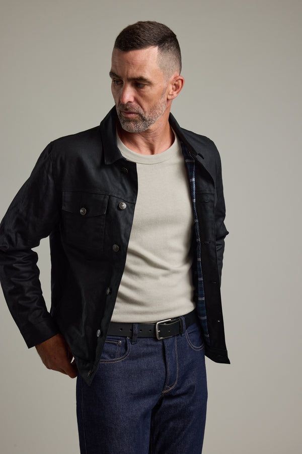 Man in Barkers Benson Waxed Cotton Jacket and white shirt against a plain background.