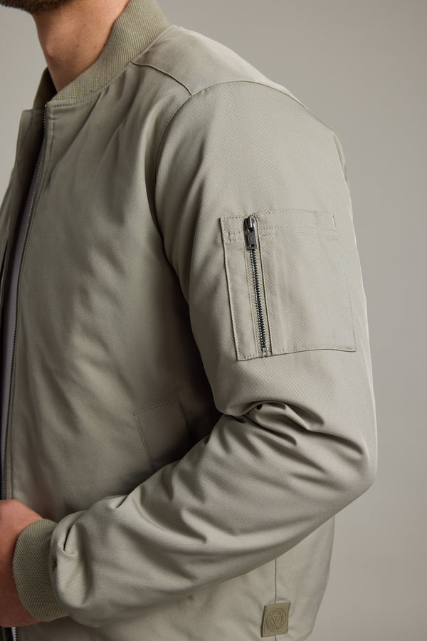 Model wears Barkers Dunhill Bomber Jacket in light gray, water-resistant with sleeve zip pocket.