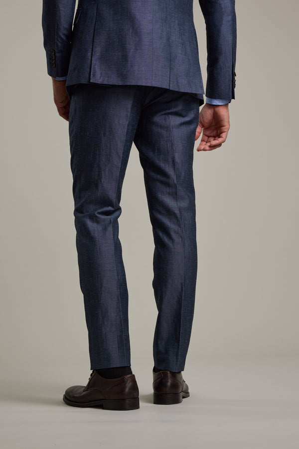 A person stands facing away in Barkers Charles Texture Suit Trouser and brown dress shoes, their left hand relaxed by their side against a plain light background.