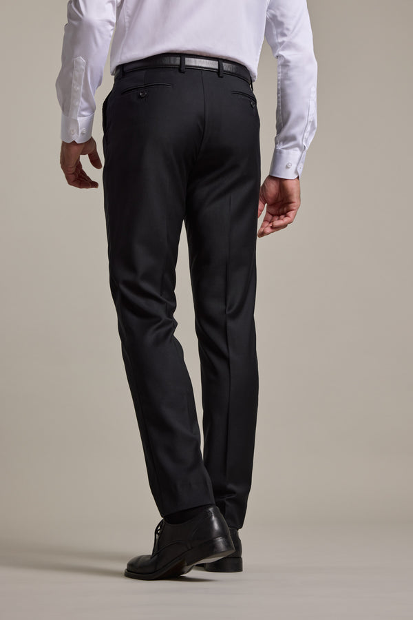 A man wearing a white dress shirt, Barkers Mayfair ZQrx Suit Trouser, and black shoes stands with his back to the camera against a plain light background.