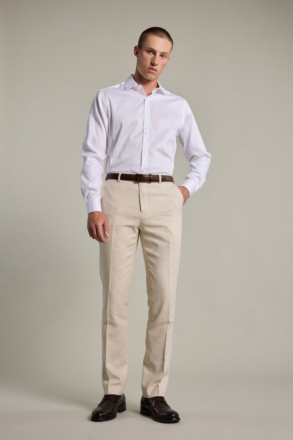 Man wears Barkers William Texture Linen Pant with a white shirt and brown shoes, background plain.