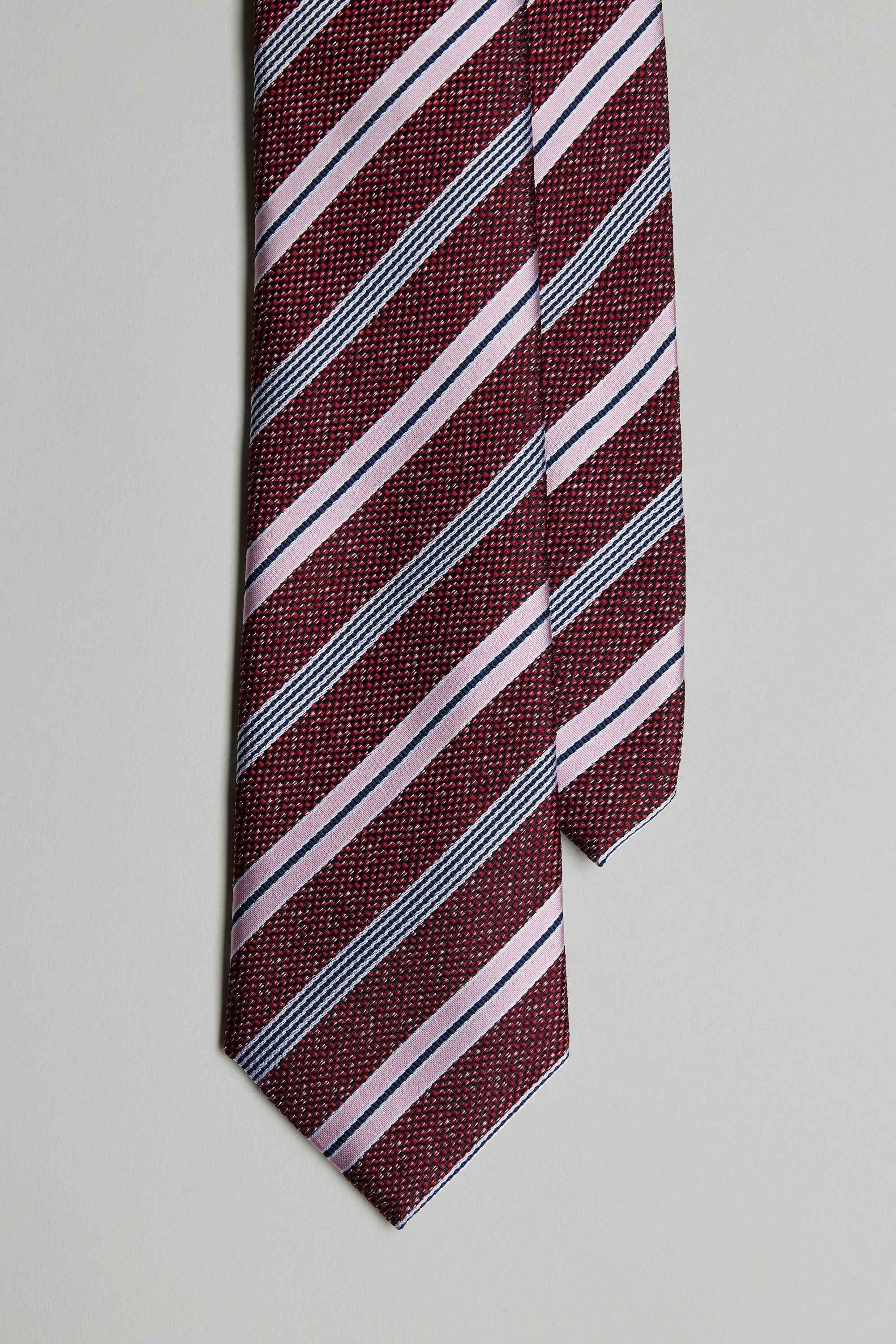 The Gracie Stripe Tie by Barkers is shown in a close-up, featuring maroon with light pink and dark gray diagonal stripes against a plain light gray background.
