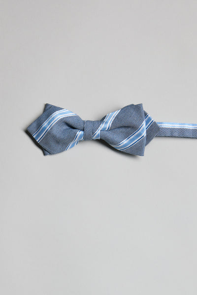The Parisian Stripe Bow Tie by Parisian is shown in blue and white on a light grey surface with its strap extended. Handmade in New Zealand, this elegant accessory brings refined charm to any formal ensemble.