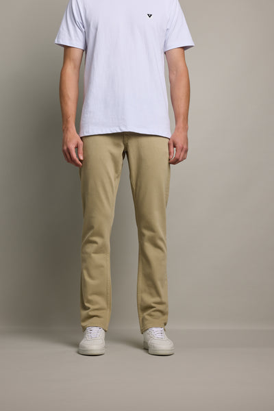 A man in a white t-shirt and Barkers Wanderer Straight Coloured Jean stands against a plain background.