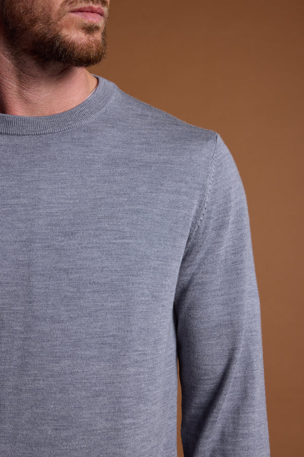 A man models the Barkers Skyland ZQrx Merino Crew in light gray, shown from the shoulders up with his head partly out of frame, set against a plain brown background.