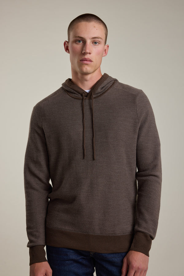 A young man with short hair wears the Barkers Roxbury Merino Hoody over a white shirt, standing against a neutral background and looking directly at the camera with a neutral expression.