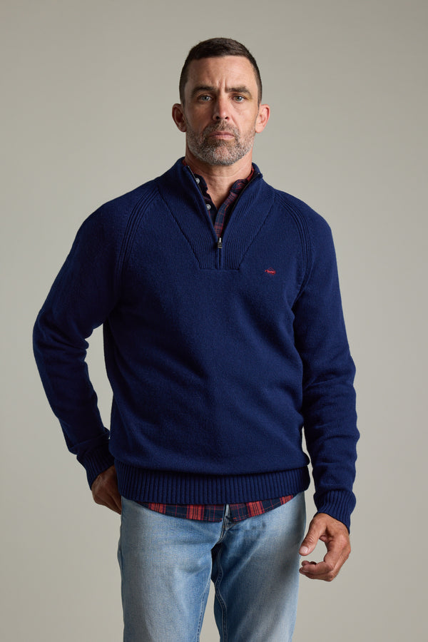 Man wears Barkers Rowley Woollen 1/4 Zip sweater over plaid shirt, plain background.