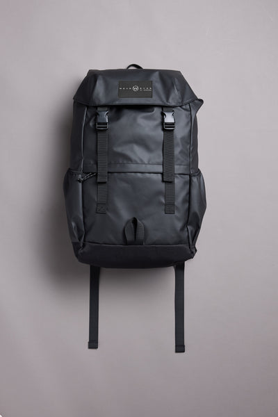 The WearEver Transit Backpack by WearEver is a sleek black bag with a top flap, two front buckles, side pockets, water-resistant zips, and a logo patch on the flap, shown upright on a plain light gray background.