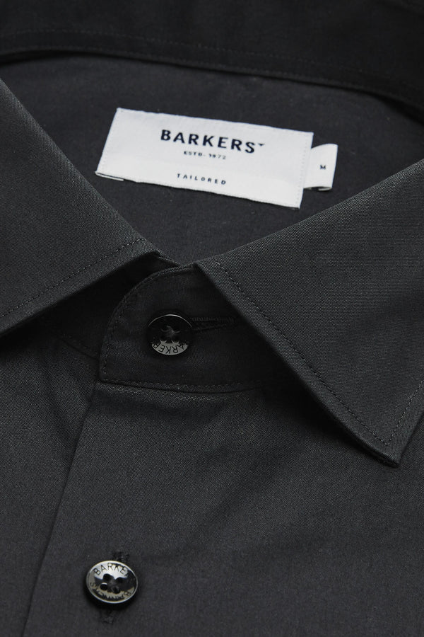Close-up of a black Tribeca Reg Cuff Shirt by Barkers, featuring two visible buttons, a “Barkers Est. 1972 Tailored” label, and an “M” size tag.