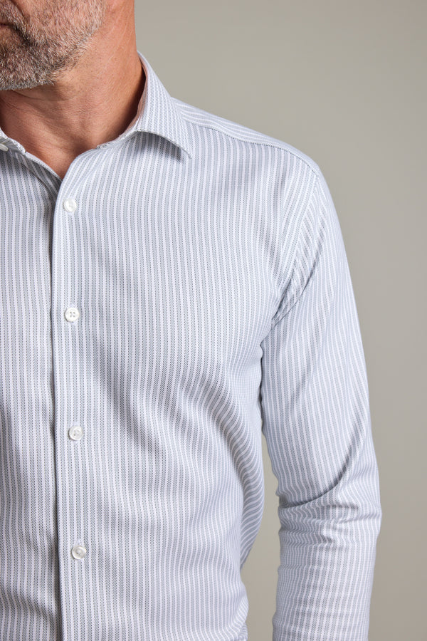 A man wears the Barkers Clarke Stripe Business Shirt, a wrinkle-free, light-colored collared shirt with vertical stripes. Shown waist-up against a plain background, only the left side of his face is partially visible.