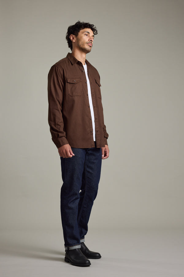 Man in a Barkers Darden Shirt, white tee, blue jeans, and black boots standing sideways.