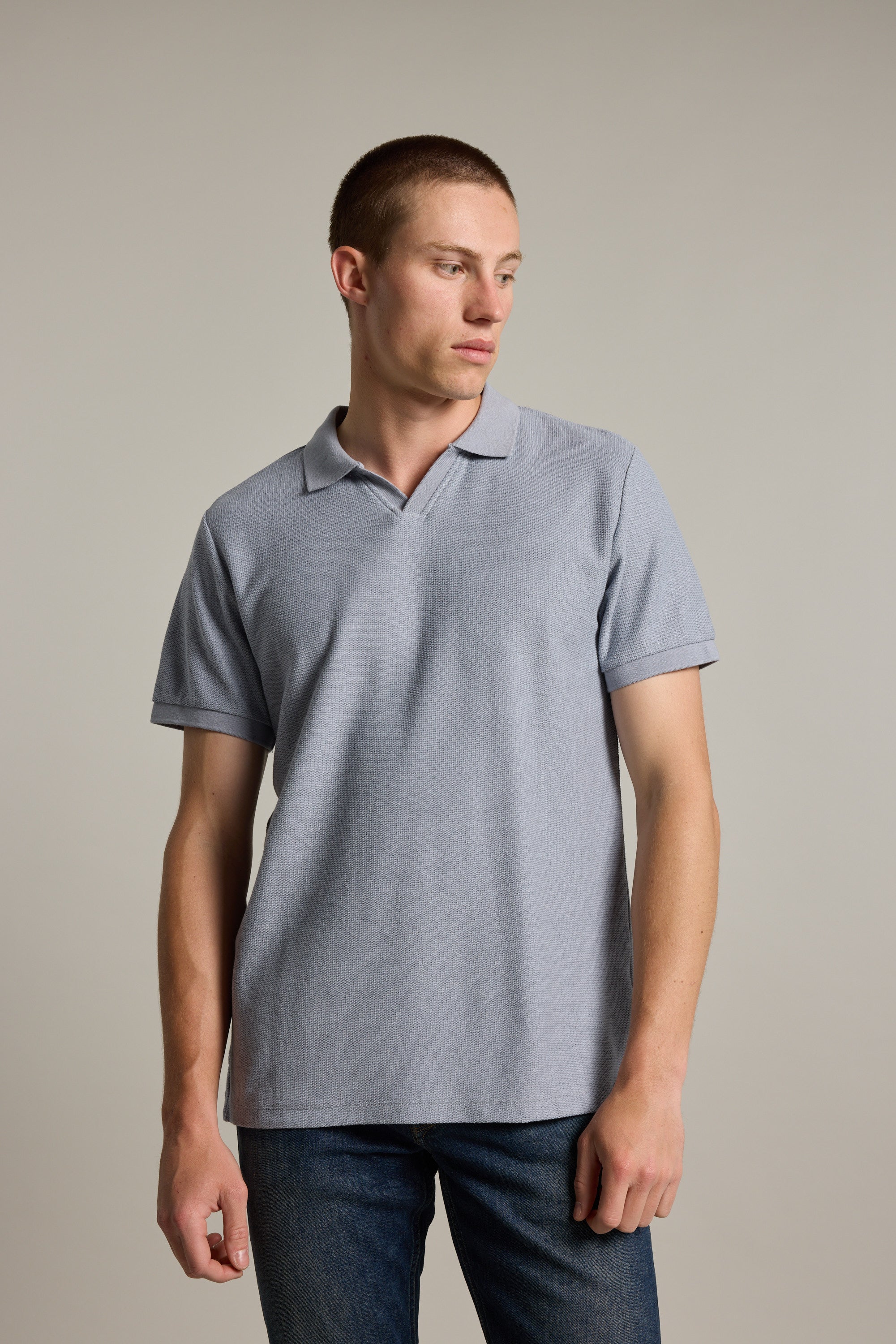 Man in a Barkers Winfield Textured Polo, made with responsibly sourced cotton, looking left.