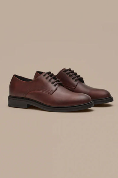The Barkers Saville Derby Shoe is a men's brown leather dress shoe with black soles, highlighting quality Portuguese craftsmanship against a plain beige background.
