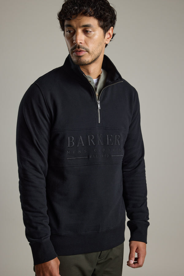 Man wearing a black Barkers Heritage 1/4 Zip with Barkers logo on the front.