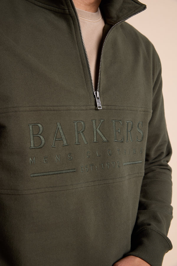 A person wearing a Barkers Heritage 1/4 Zip sweater in olive green.