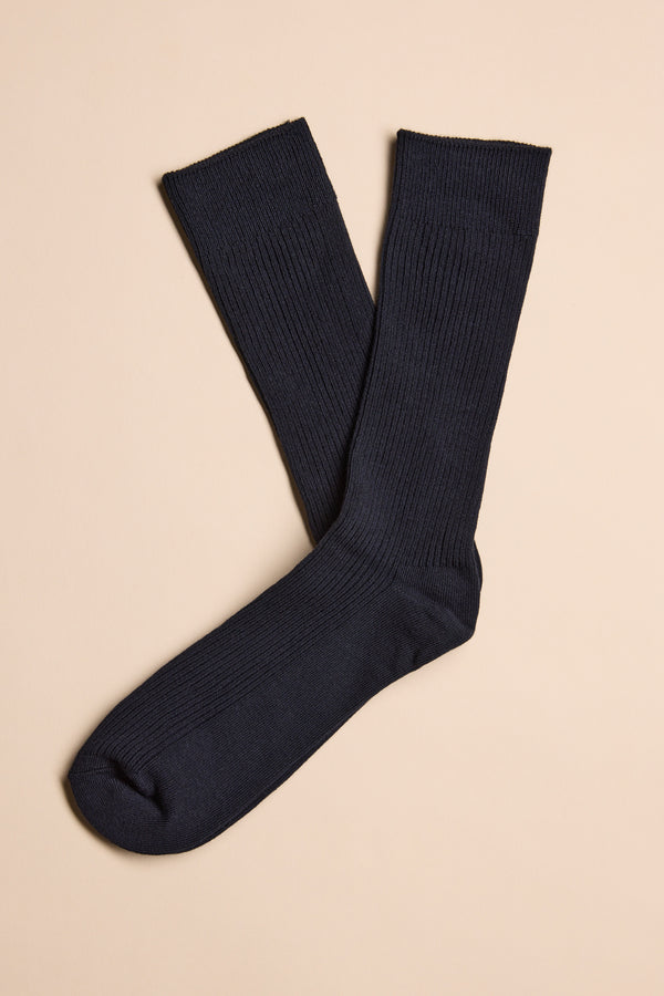 A pair of long, dark navy Barkers Business Socks by Barkers, made from responsibly sourced cotton, laid flat on a light beige background with one sock slightly overlapping the other.