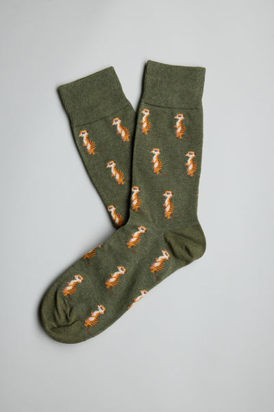 The Barkers Jarvi Meerkat Sock is a green pair featuring a repeating pattern of small orange and white standing meerkats, shown laid flat with one sock overlapping the other on a light grey background.