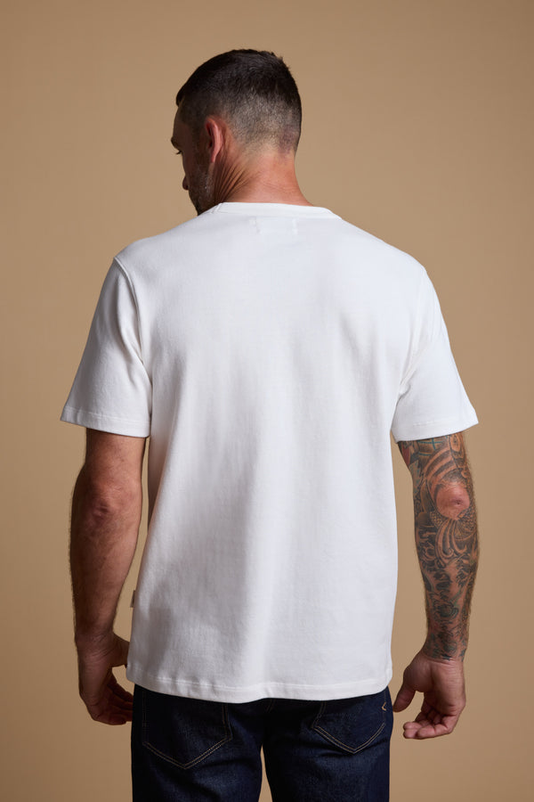 Man wearing Barkers Langwood Tee and jeans, shown from the back on a beige background.