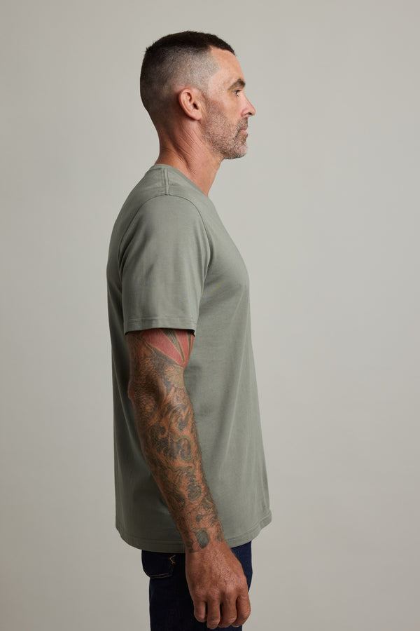 Man in Barkers Good Earth Cotton Essential Tee, traceable cotton, gray, stands in profile.