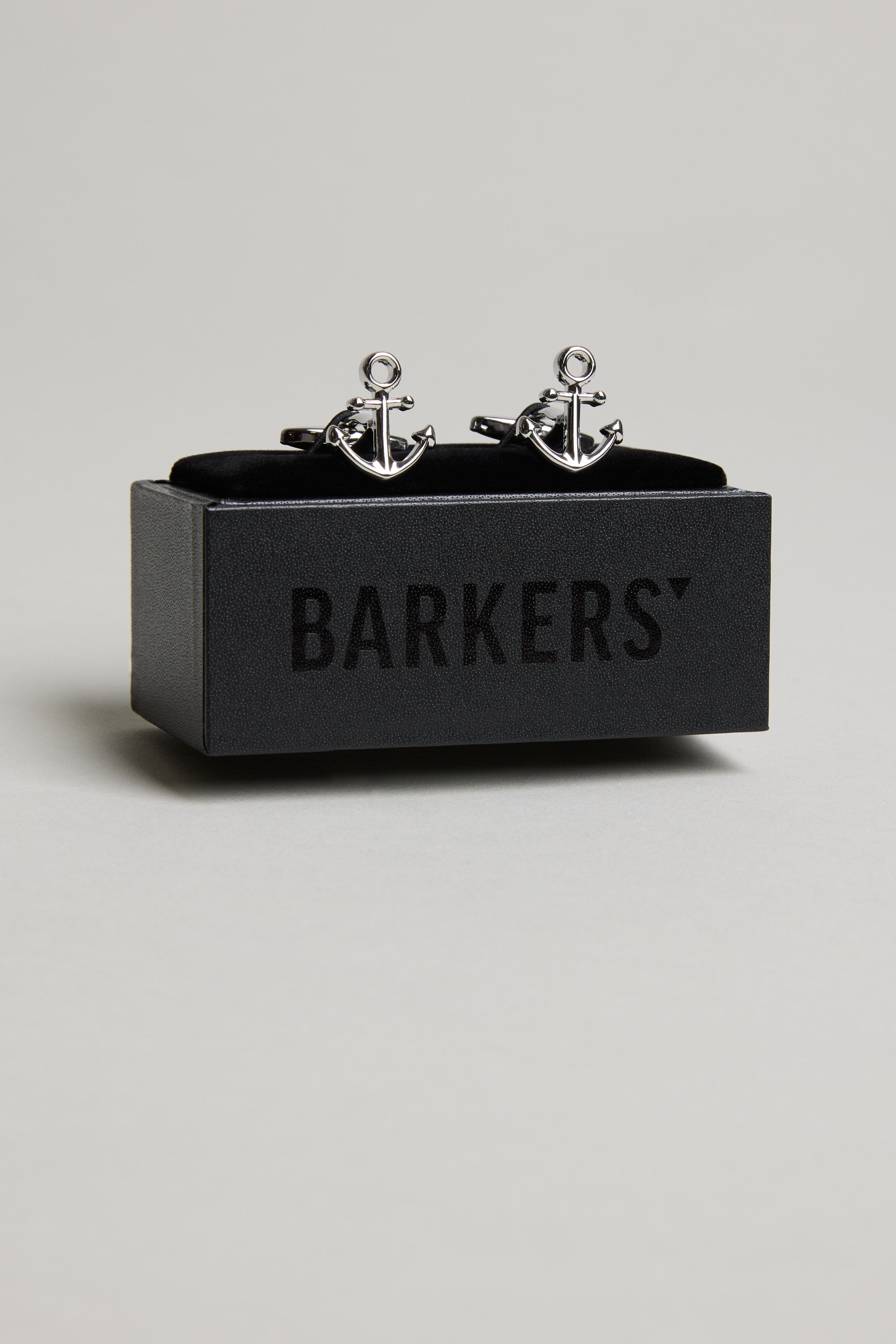 A pair of Barkers Anchor Cufflinks is displayed on a black box with "BARKERS" printed on it, set against a plain light grey background.