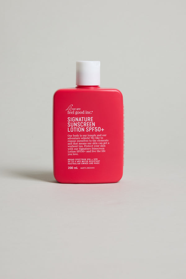 A red rectangular bottle labeled Feel Good 50+ SPF Sunscreen by Other with broad spectrum protection stands upright on a light gray surface. The white-capped bottle contains 200 ml of product.