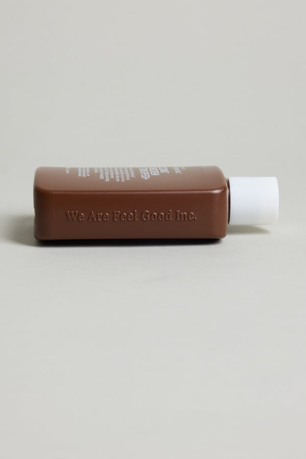 Brown rectangular bottle of Feel Good 50+ SPF Coconut Sunscreen by Other, white cap.