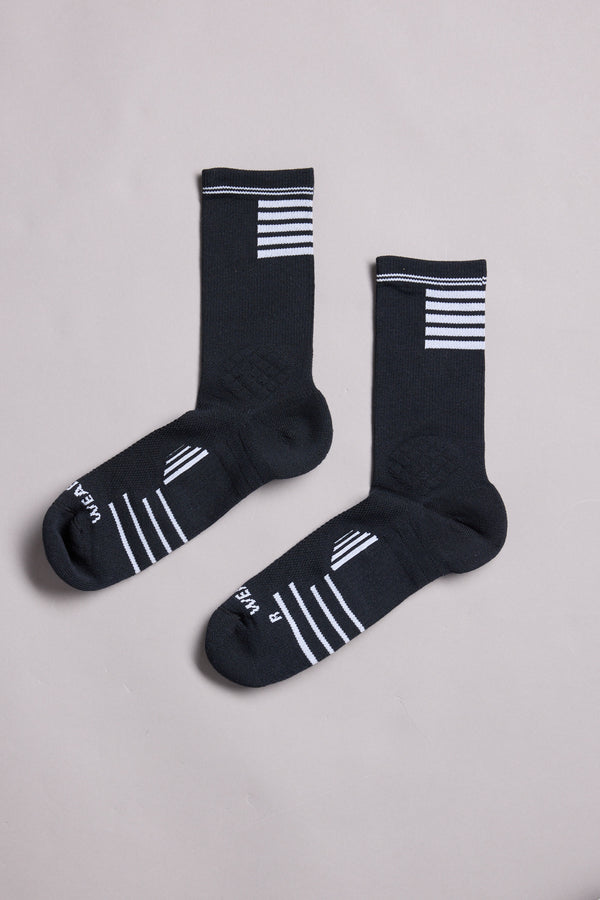 A pair of WearEver Active Socks by WearEver, made in New Zealand, in black with white stripes at the top and on the feet, labeled L and R for left and right, displayed on a plain light gray background.
