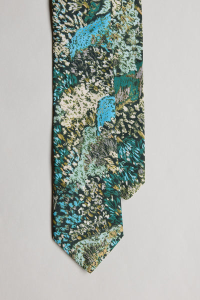A close-up of the Liberty Darley Hillside Tie by Liberty, handmade in New Zealand from Tana Lawn cotton, with an abstract textured pattern in blue, green, black, and cream on a white background.