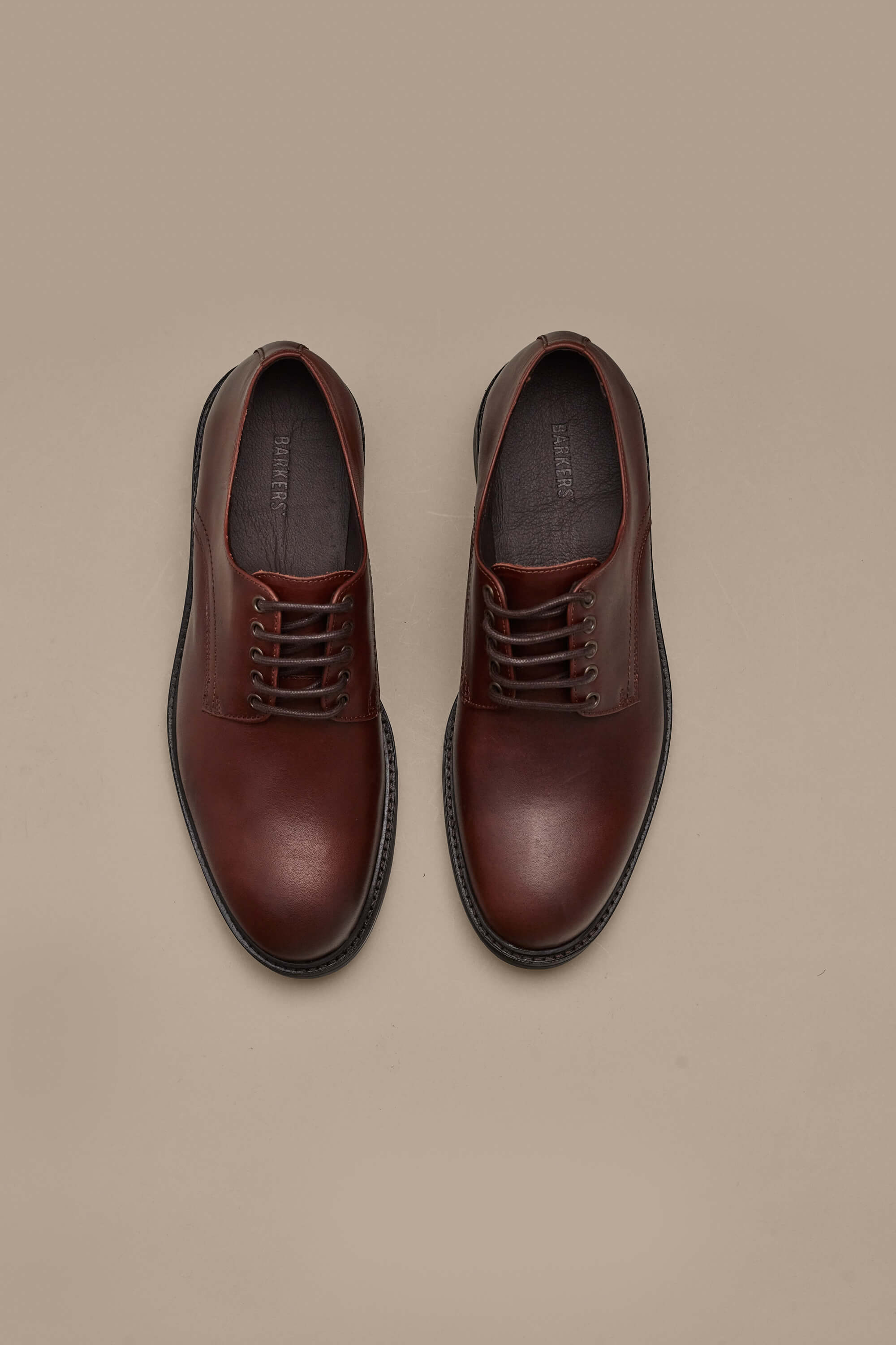 A pair of Saville Derby Shoes by Barkers is displayed side by side on a light beige background, highlighting quality Portuguese craftsmanship and timeless men's style.