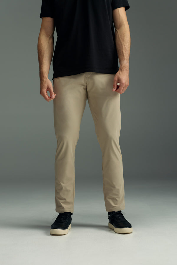 A person wearing a black t-shirt, WearEver Long Game Pant by WearEver, and black sneakers stands against a plain gray background. The image is cropped at the shoulders so the head is not visible.