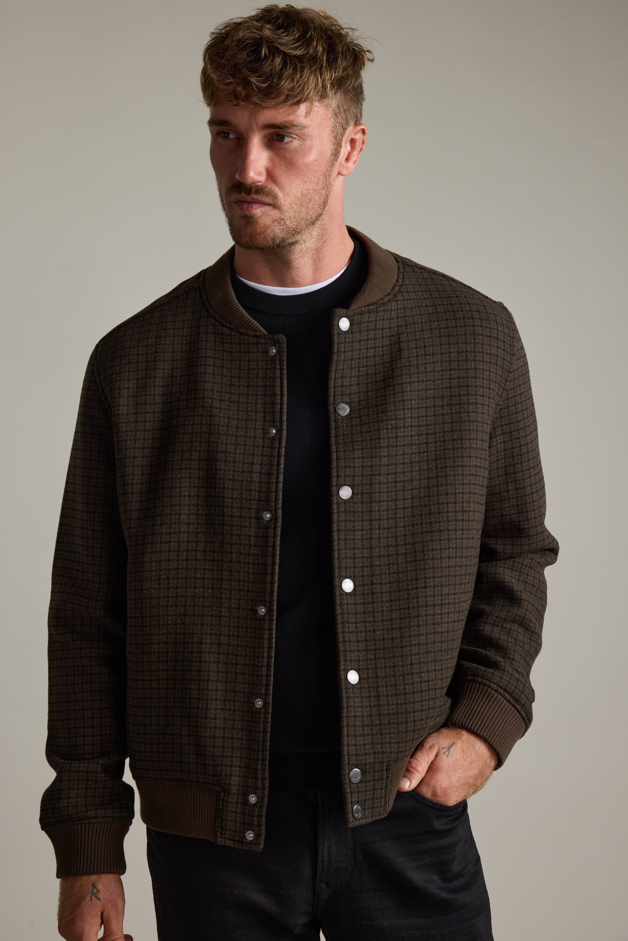 Man wears Barkers Leland Wool Bomber Jacket over a black shirt, styled as transeasonal.
