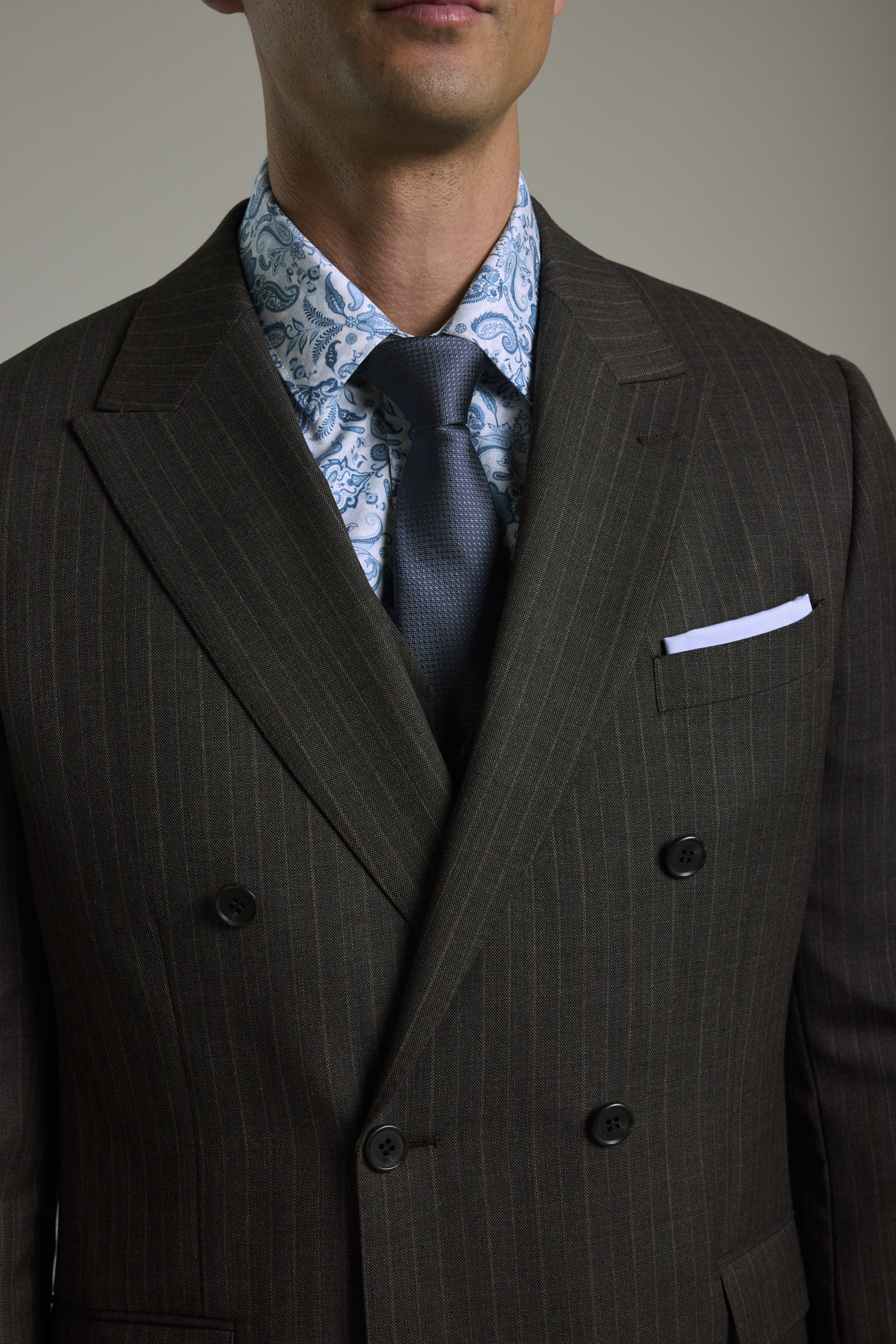 Man in Barkers Radcliffe Stripe Double Breasted Suit Jacket, blue paisley shirt, navy tie.