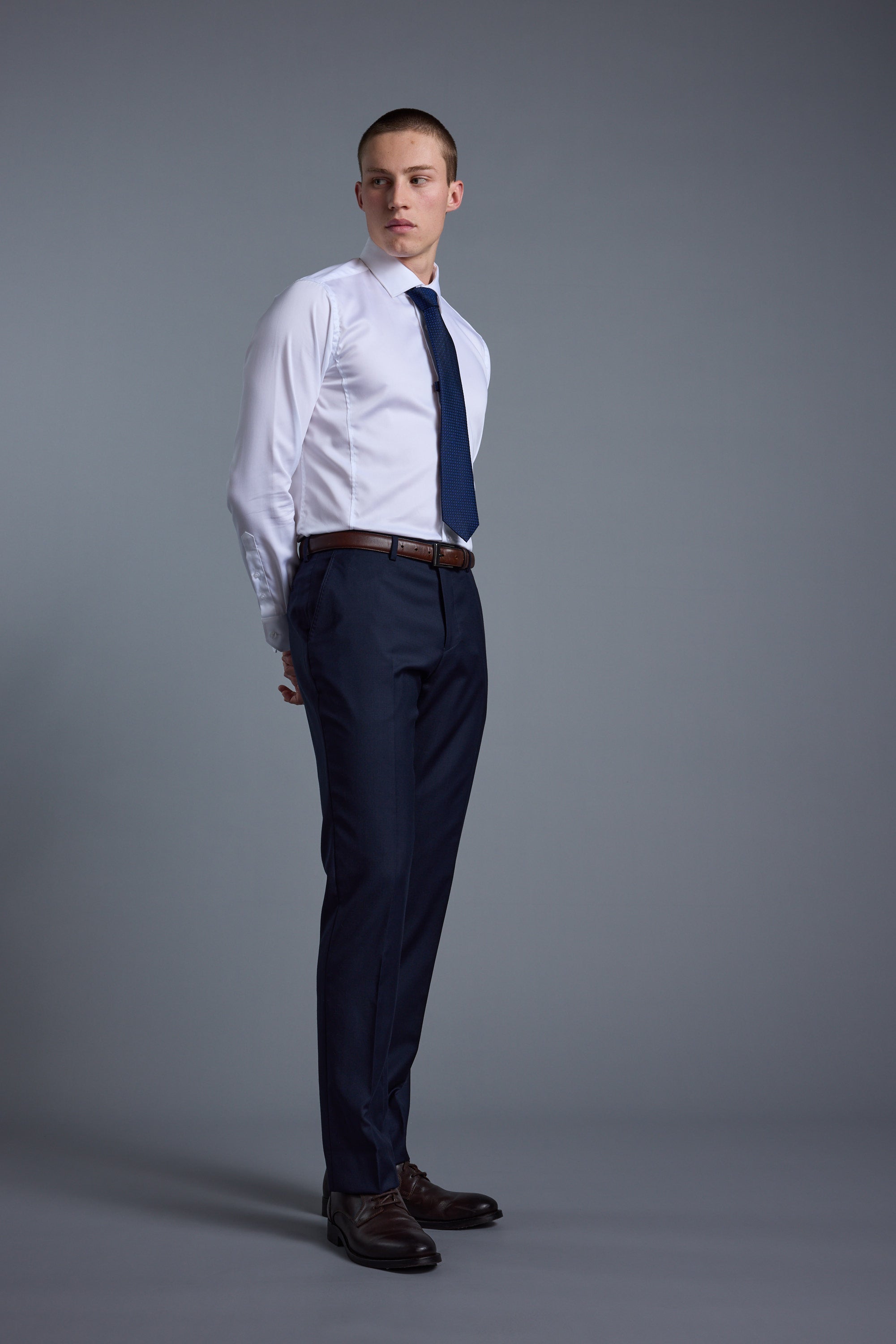 Man in Barkers Mayfair ZQrx Suit Trouser stands against a plain gray background.