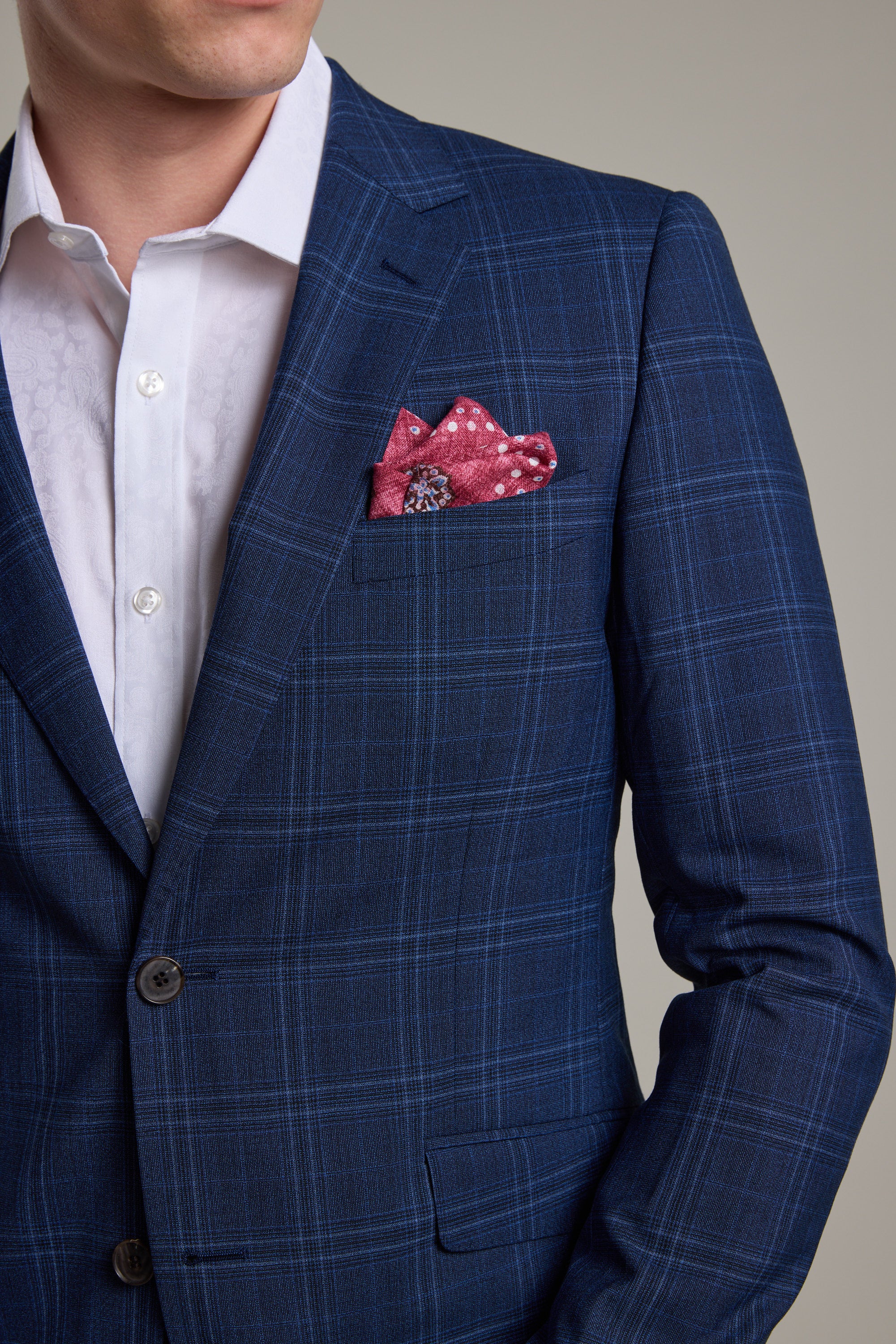 A man wears the Barkers Leonard Check Suit Jacket over a white dress shirt, with a pink patterned pocket square. The image is cropped to show only his shoulders and upper chest.