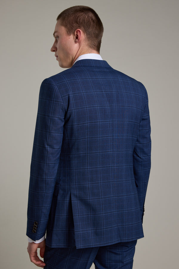 A man stands facing away, displaying the back of the Barkers Leonard Check Suit Jacket in navy with a subtle windowpane grid, set against a plain light gray background.