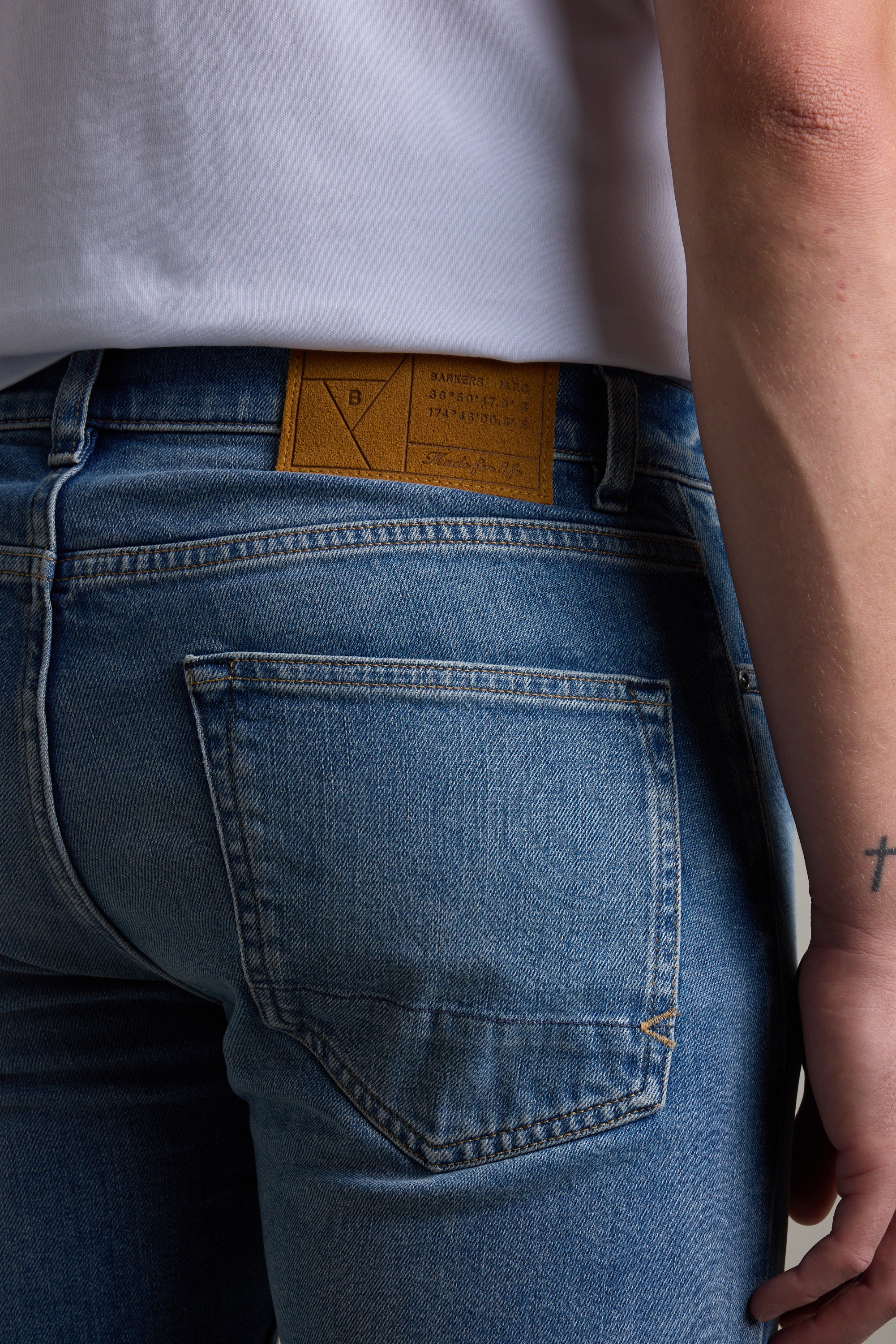 Model in Barkers Rambler Denim Slim Jean, highlighting back pocket and branded waistband label.
