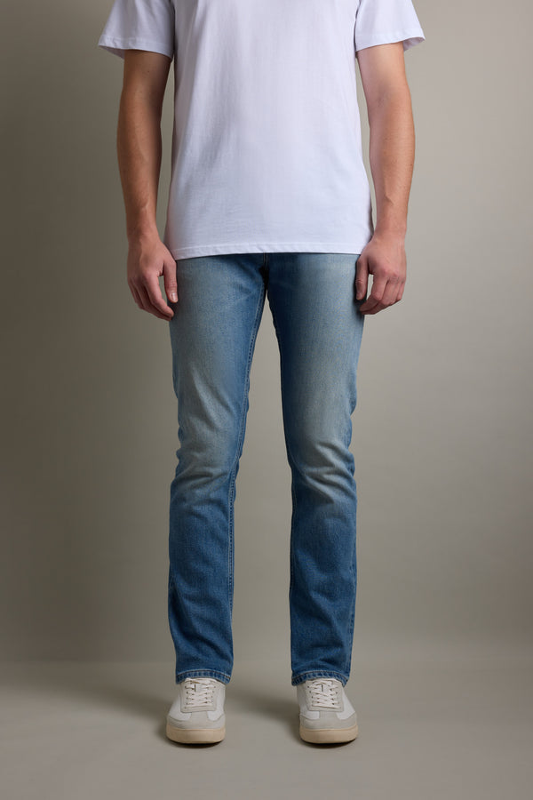 Person wearing a white t-shirt, Barkers Wanderer Denim Straight Jean, and white sneakers.