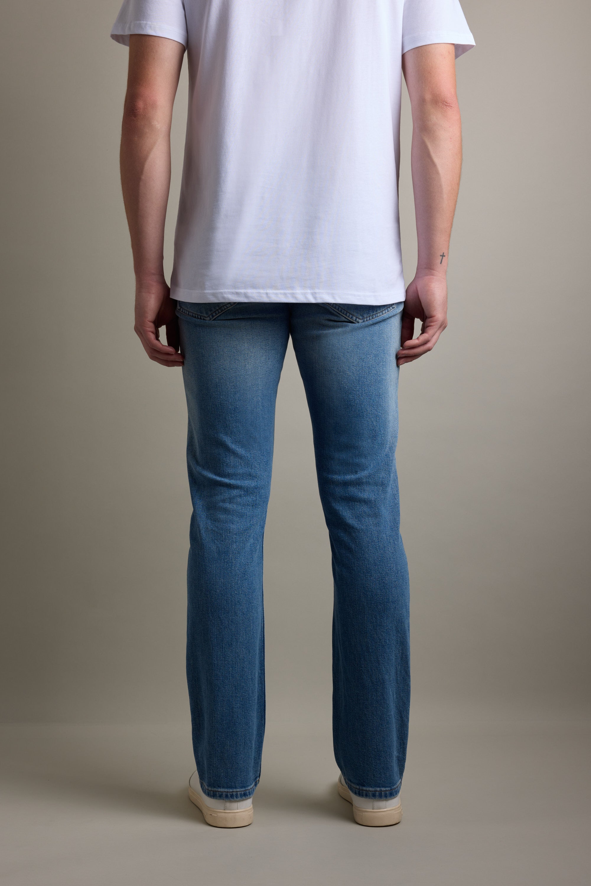 Person standing, facing away, in a white t-shirt and Barkers Wanderer Denim Straight Jeans.