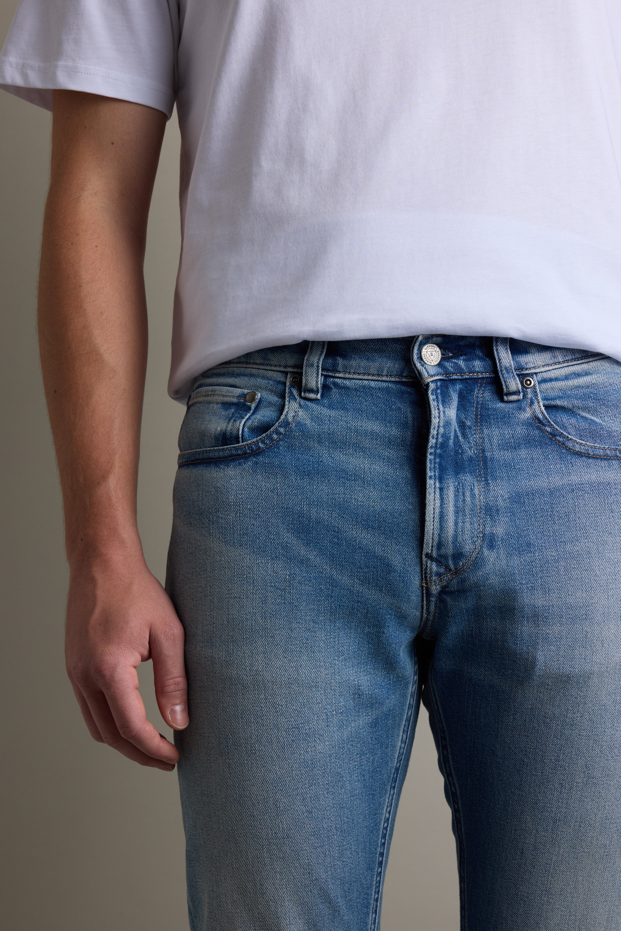 Person wearing a white t-shirt and Barkers Wanderer Denim Straight Jean, shoulders to mid-thigh visible.