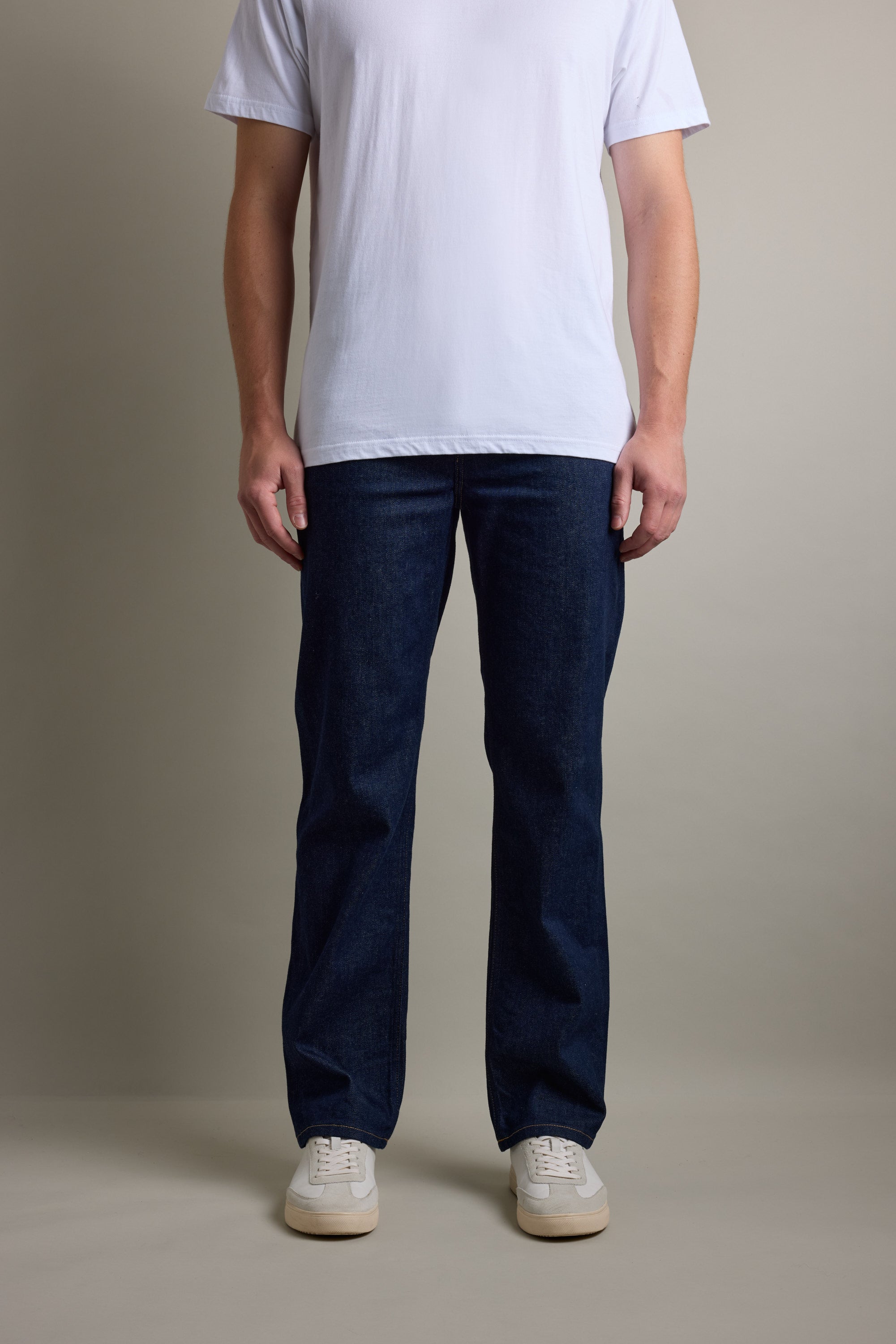 Person wears a white tee, Barkers Drifter Denim Relax Jean, and white sneakers on a plain background.