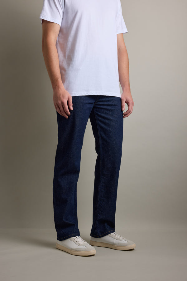 Man in a white tee, Barkers Drifter Denim Relax Jean, and white sneakers on a plain background.