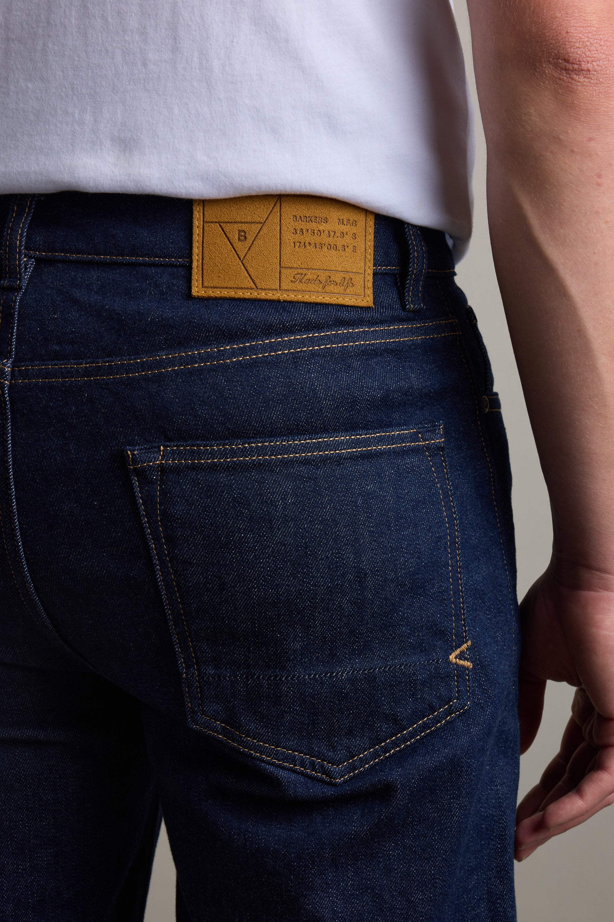 Person in Barkers Drifter Denim Relax Jean, displaying the back pocket and leather label.