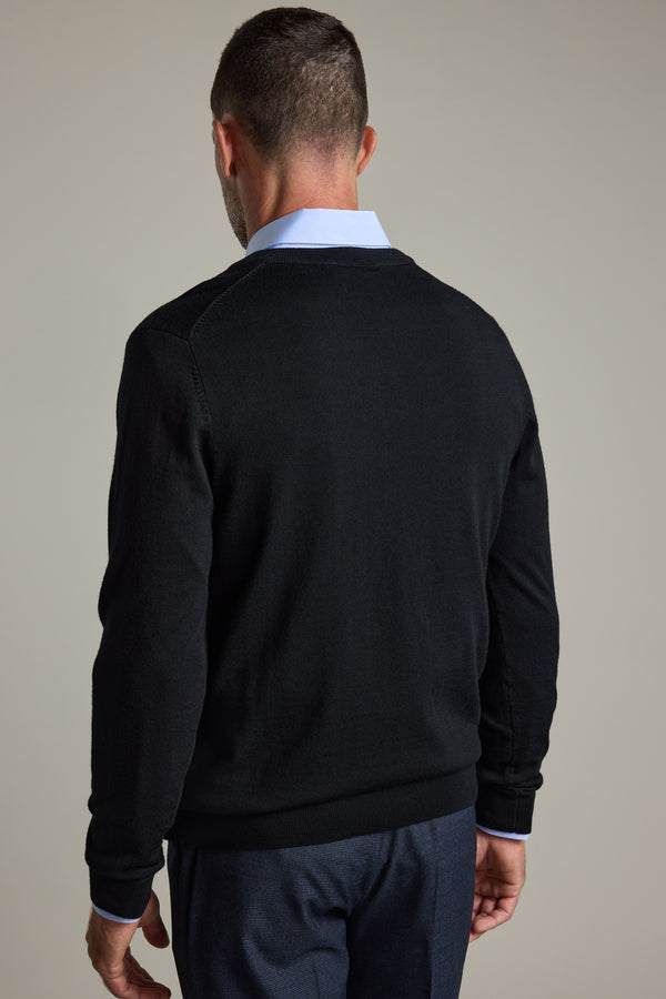 A man in a Barkers Skyland ZQrx Merino Vee black sweater and blue shirt, seen from behind.