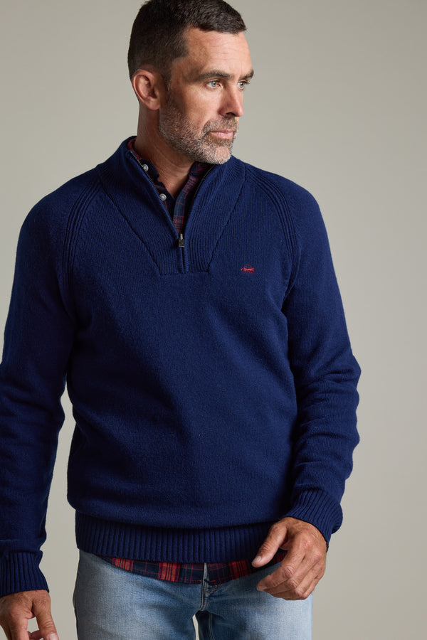Man wears Barkers Rowley Woollen 1/4 Zip sweater and jeans, looking to the side.