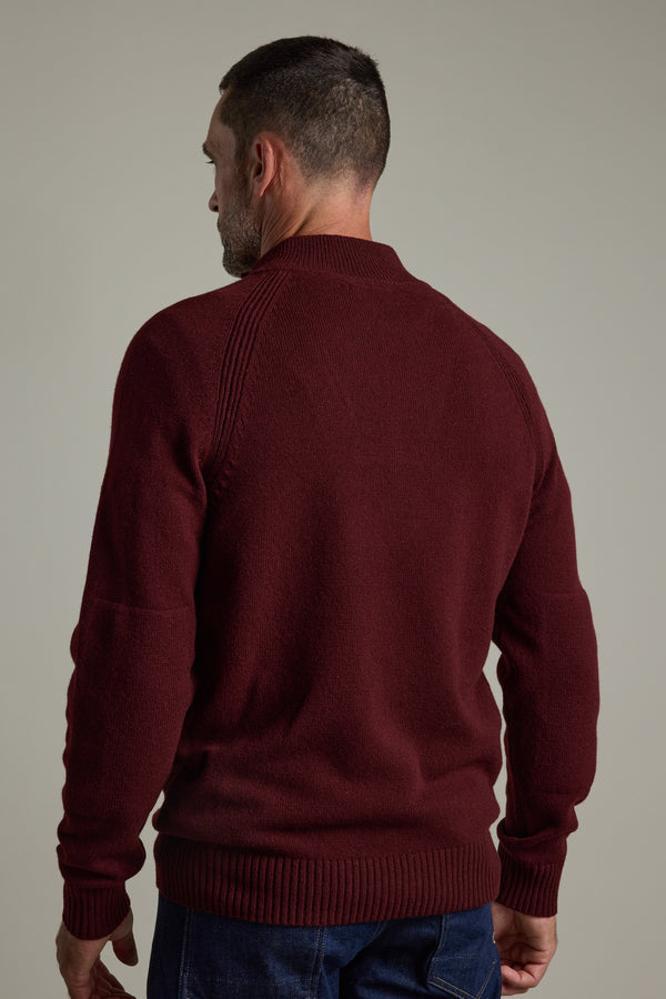 Man in a Barkers Rowley Woollen 1/4 Zip and jeans standing with his back to the camera.